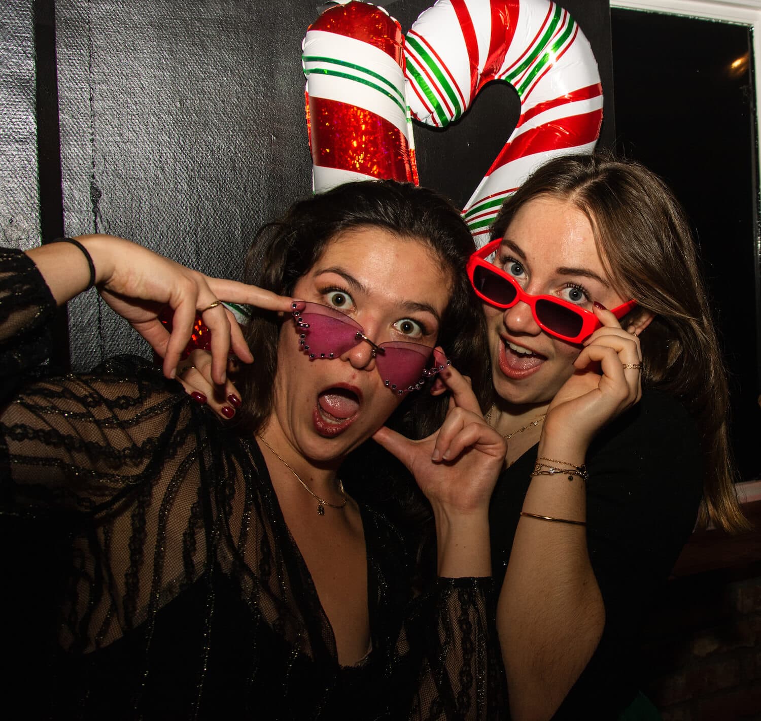 Two girls with lifted sunglasses saying what? in Akademien Nightclub.